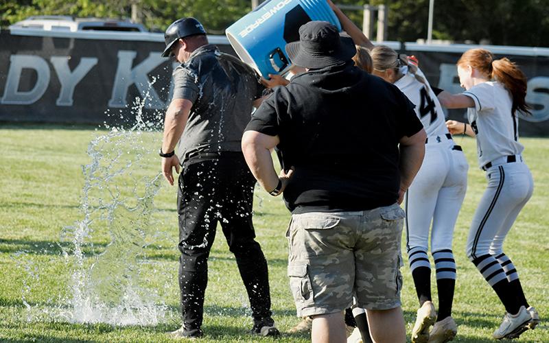 Robbinsville head coach Billy Knight receives a customary bath Monday, after leading the Lady Knights to their 17th Smoky Mountain Conference title. Delivering the free shower were Loxley Burke (not visible), Anna Williams (4) and Kynadee Spencer (1). Photo by Bella Eddings/The Graham Star