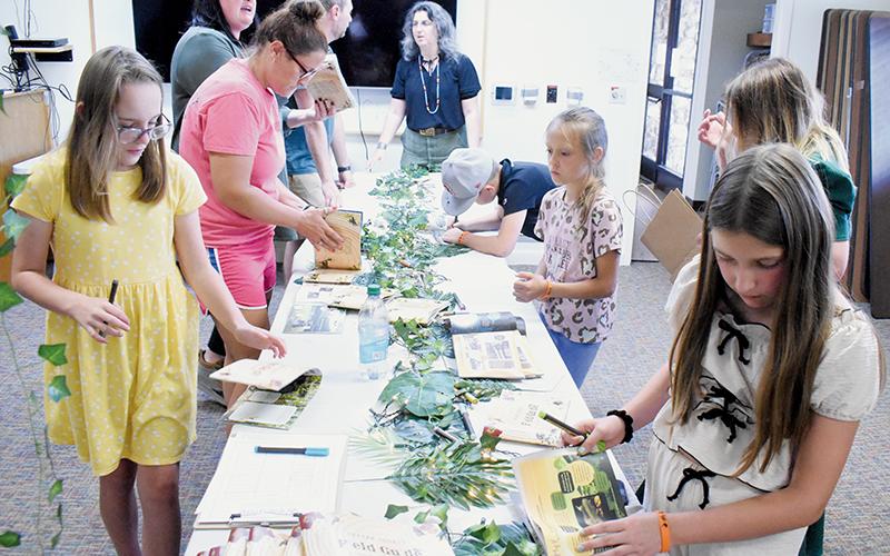 Students from Robin Welker’s third-grade class clamor around a table inside the Graham County Public Library on June 10, to sign copies of their self-produced Graham County Field Guide. Photos by Kevin Hensley/editor@grahamstar.com