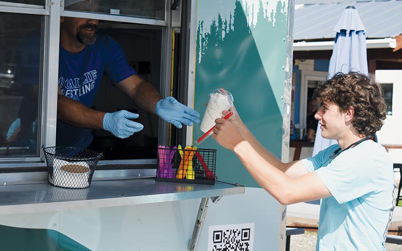 Mountain View Creamery's Chris Williams hands a freshly spun milkshake to a  customer on June 19. The dessert stand just opened a few weeks ago and is the  latest to join a quickly growing population of food trucks in Robbinsville.