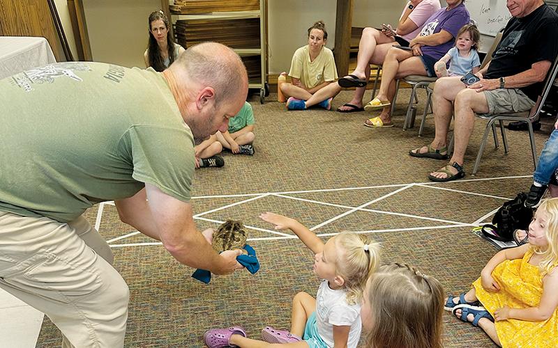 Naomi Buchanan reaches to pet “Trevor” during June 5’s Wildlife Wonders exhibition at the Graham County Public Library. Photos by Latresa Phillips/The Graham Star