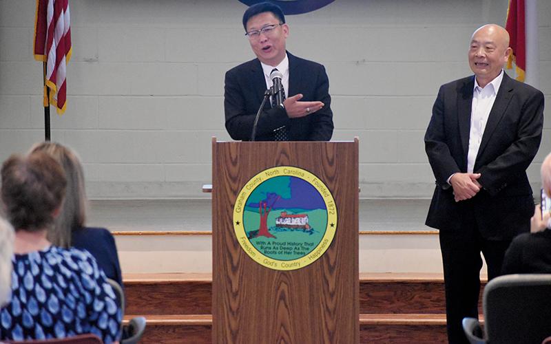 EcoKing Solution Chairman Ping Zhang heartedly addresses those on-hand for Tuesday's press conference at the Graham County Community Building, where it was revealed that the China-based manufacturer will create 300 new jobs in the region during its first phase of operations in Robbinsville. At Zhang's left is vice president John Lin.