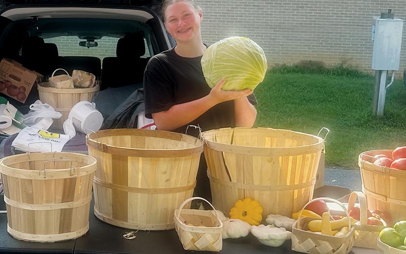 Oakley Pressley brings crops from one of her four gardens to sell at the Graham County Farmers Market, as part of the market’s youth entreprenuership initiative. Her tent is aptly titled “Fresh Pickins.’”