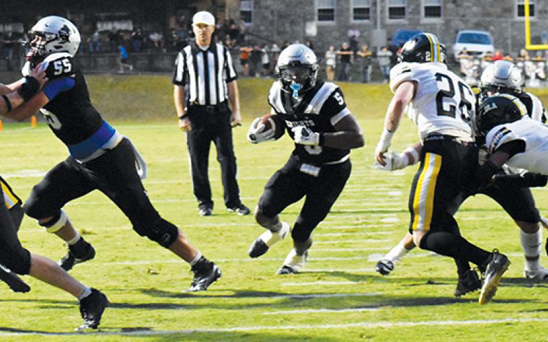 Kyzik Teesateskie gladly takes advantage of the hole opened up by defenders Christian Koeller (33), Kasen  Buchanan (55) and Kellen Ensley to score his second rushing touchdown of the first half Friday against Tuscola. Photo by Bella Eddings/The Graham Star