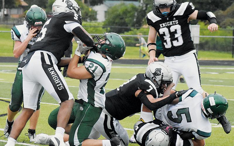 A pair of East Henderson players suffer the consequences of running into  Robbinsville's Kyzik Teesateskie (5), Isiac Collins (7) and Kellen Ensley (54) during Friday's scrimmage with the Eagles. Photo by Lexie Anderson/The Graham Star