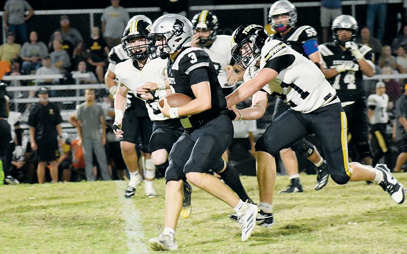Luke Lovin evades the pursuit of Tuscola defenders while gaining positive yardage in Friday's season opener. Lovin will be Robbinsville's quarterback for the 2025 season. Photos by Bella Eddings/The Graham Star