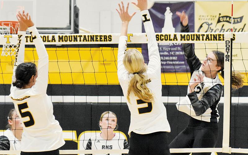 Outside hitter Chloe Adams delivers a spike between the outstretched defense of Tuscola’s Julia Wells (5) and Ivy Jones (3) during Monday’s season opener. Photo by Bella Eddings/The Graham Star