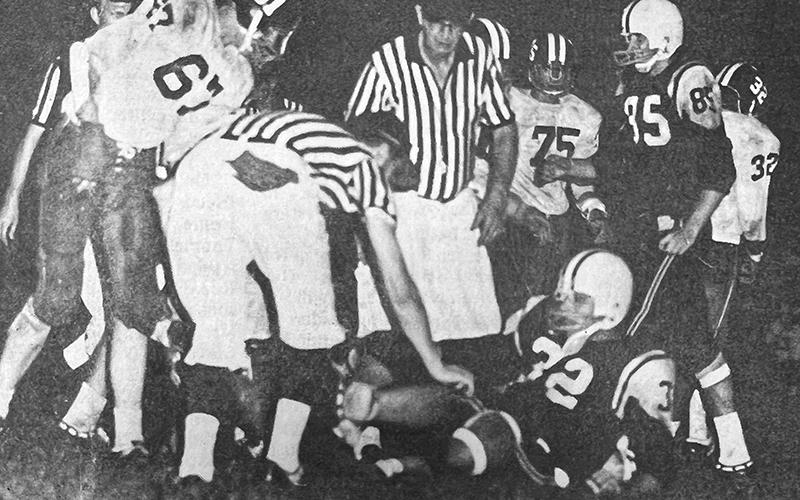 With his chin strap loosened, Larry Sawyer struggles to his feet after earning a first down in Robbinsville's season-opening victory over Andrews on Sept. 4, 1970.