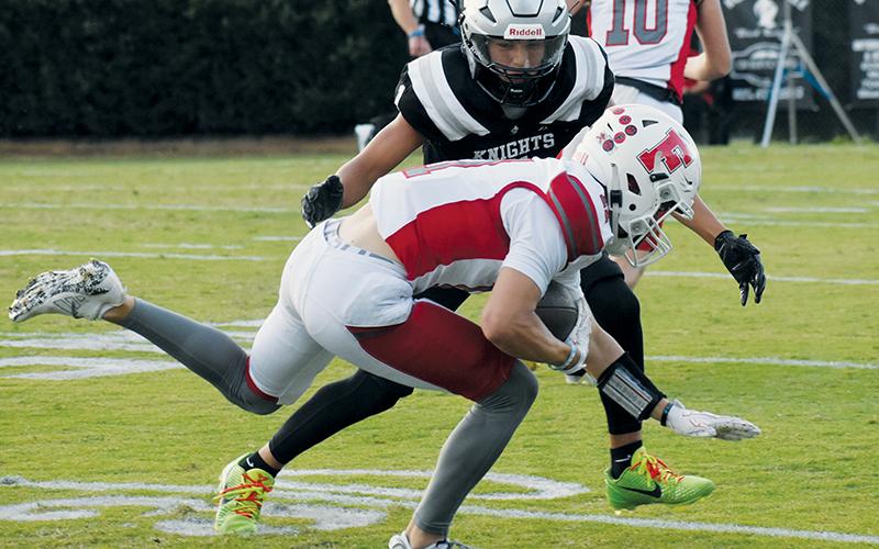 Black Knight Xamuel Wachacha closes in to wrap up Franklin's Gabe Harrison during the first quarter of Friday's appointment with the Panthers.