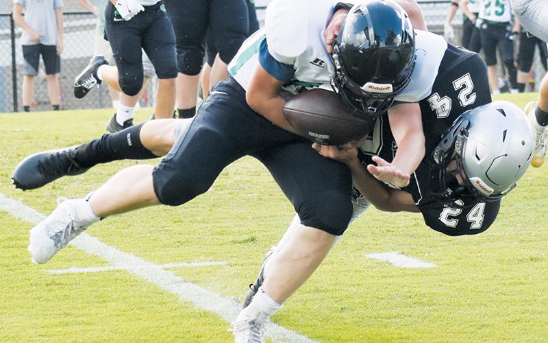 JV Black Knight Mason Silvers tackles a Mountain Heritage ball carrier during Aug. 21's season opener. Robbinsville's defense has held opponents scoreless thus far this season. Photo by Lexie Anderson/The Graham Star