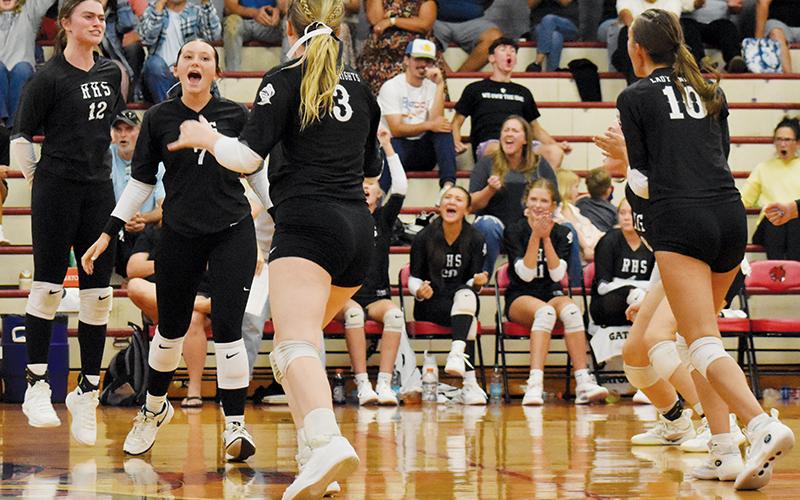 Members of the Robbinsville Lady Knights volleyball team and fanbase erupt in celebration after a big point was scored during Aug. 28's five-set victory at Andrews. Players visibly celebrating on the floor are Chloe Adams (10), Ella McGuire (7), Daphne Barlow (3) and Izabel Haney (10). Photo by Bella Eddings/The Graham Star