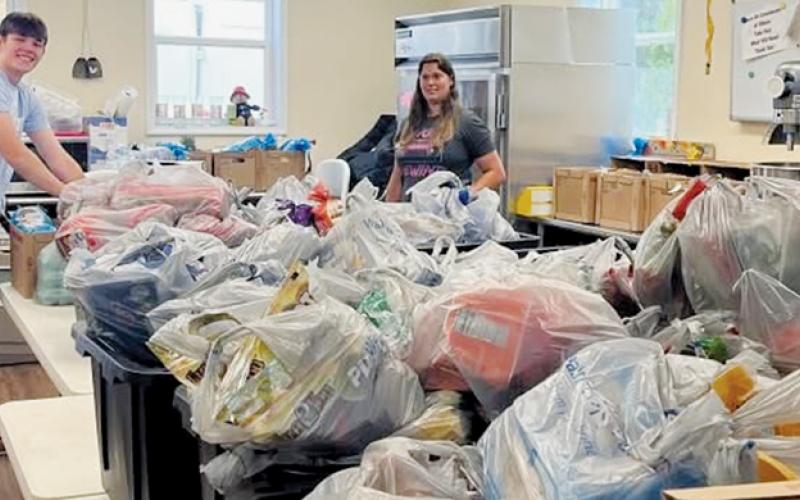 Nathanael Shope (left) and Terra Fouts stand with just a sample of the food collected to provide a Thanksgiving meal at Grace Place, A Community Table.
