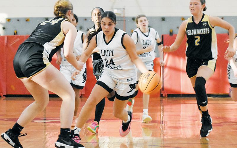 Robbinsville's McKynlee Adams splits the defense of Hayesville's Ayden Margo (24) and Kaelyn Cook (2) during Monday's season opener. Photo by Kevin Hensley/sports@grahamstar.com