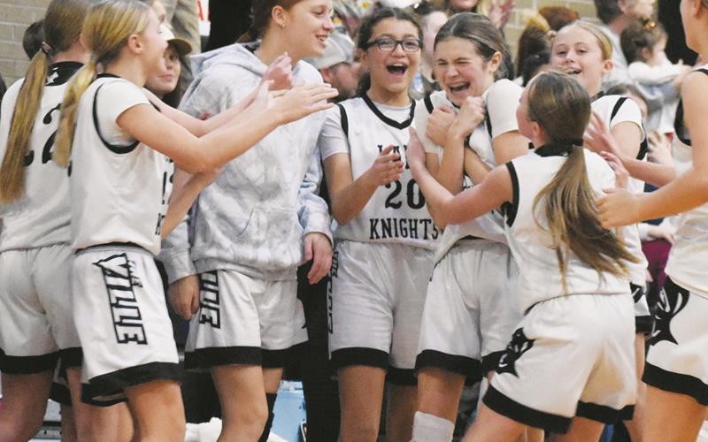 Teammates mob Robbinsville Middle School's Mercy Nelms (center) on Dec. 4, moments after Nelms hit a three-pointer at the final buzzer to cement a 42-34 home victory over Swain County. Photo by Kevin Hensley/sports@grahamstar.com