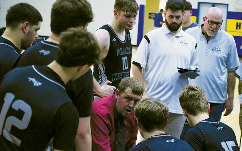 Black Knights head coach Jake Beasley (center, kneeling) talks strategy with his team, shortly before the second half of Jan. 8's road game against Highlands gets underway. Photo by Kevin Hensley/sports@grahamstar.com