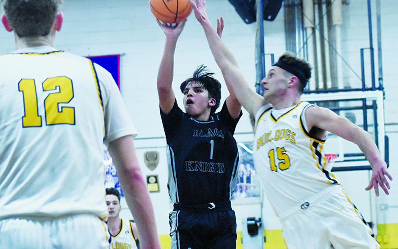 Xamuel Wachacha (1) attempts to evade the defense of Murphy's Abram Twiggs and shoot a 3-pointer during Feb. 12's Smoky Mountain Conference title game. Photos by Bella Eddings/The Graham Star