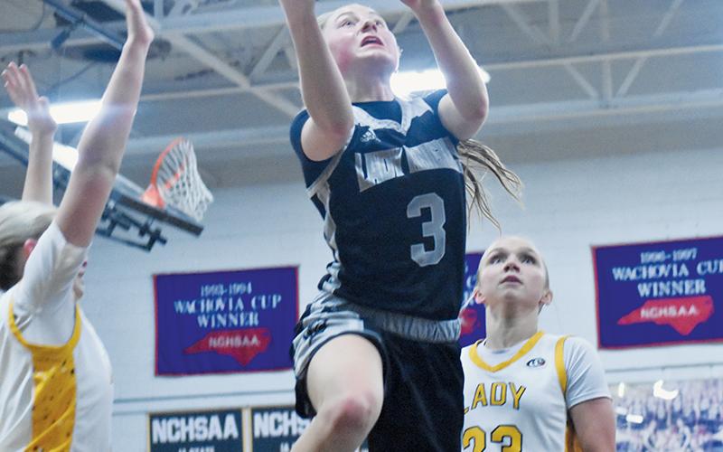 Robbinsville senior Abby Wehr splits the defense of Murphy's Kennedy White (3) and Emma Hensley (23) for a second-half lay-up attempt Feb. 12. Photos by Bella Eddings/The Graham Star