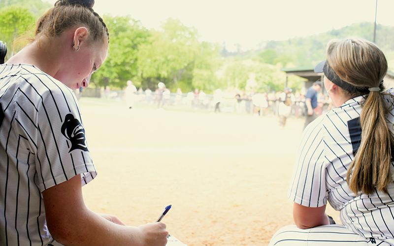 Robbinsville freshman Ella Nelms (left) has not been content filling out a pitch-count chart over the last two weeks – but it's all the ace of the Lady Knights pitching staff is capable of, after being sidelined with an injury. Nelms is expected to return to action during Friday's season finale against Murphy. Photo by Kevin Hensley/sports@grahamstar.com