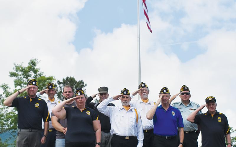 Veterans stand in front of the massive flag that was raised for the first time Memorial Day off Old Tallulah Road. All names are listed from left in each row. Front row: Amanda Gyongyos, Rudy Leopold, Barry Watkins and Billy Cable. Second row: Travis Brooks, Caleb Stiles, Joseph Vasquez, Hubert Merchant and Buddy Adams. Standing in back is Harold Phillips. Photo by Lexie Anderson/The Graham Star