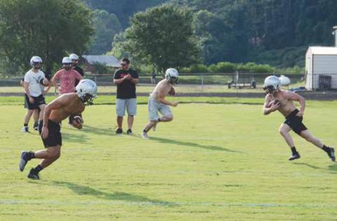 Coach Lucas Ford encourages Rylee Anderson, Bryce Coats and Lex Hooper during an agility drill during the first day of practice Thursday.