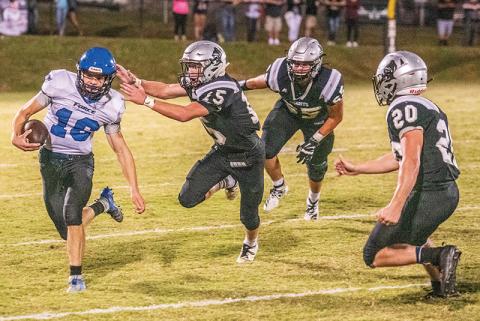Robbinsville’s Clayson Lane (15), Grady Garland (65) and Lex Hooper close in on Georgia Force quarterback Kyle Moseley during Friday’s non-conference finale. Photo by Byron Housley/The Graham Star