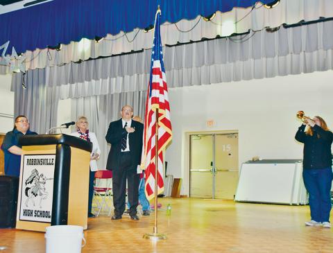 As Matthew Miller played “Taps,” Town of Robbinsville Alderman Brian Johnson, Connie Orr of the Graham County Board of Commissioners and Town of Robbinsville Mayor Steve Hooper (from left) honored the flag at the beginning of Monday’s Veterans Day ceremony at  Robbinsville High School. Photos by Art Miller/amiller@grahamstar.com