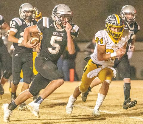 Robbinsville quarterback Nathan Collins (5) looks to outpace the defense of  Murphy’s Ray Rathburn during Friday’s third-round playoff game. Collins had two rushing touchdowns in the Knights’ 24-13 win over the Bulldogs. Photos by Byron Housley/The Graham Star