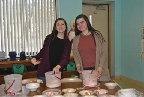 Robbinsville High School HOSA President Emma Nichols (left) and Addison Moody serve ice cream to high school students for reaching the service project goal.