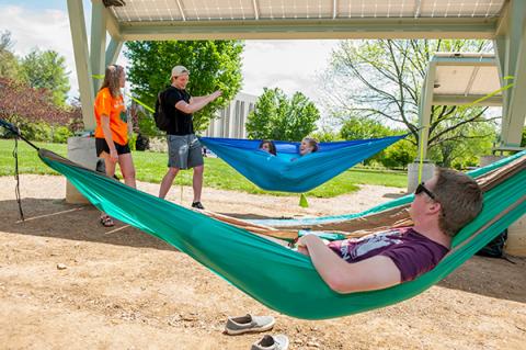 Students enjoy a sunny day at WCU’s Electron Garden on the Green, a power-producing 10-kilowatt solar photovoltaic system and hammock hanging lounge.