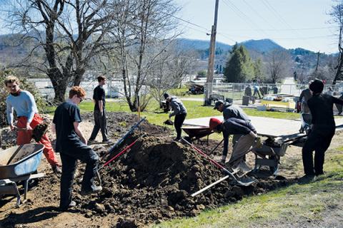 Volunteers work on the new community garden that has sprouted behind the Church Mouse Thrift Store in downtown Robbinsville. Photo by Art Miller/amiller@grahamstar.com
