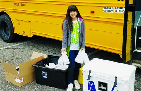 Sarai Moreno, a sixth-grader at Robbinsville Elementary School, took full advantage of the meal distribution program put in-place by Graham County Schools by visiting Robbinsville United Methodist Church for lunch and next day’s breakfast on March 18. Photo by Eric Reece/Contributing Photographer