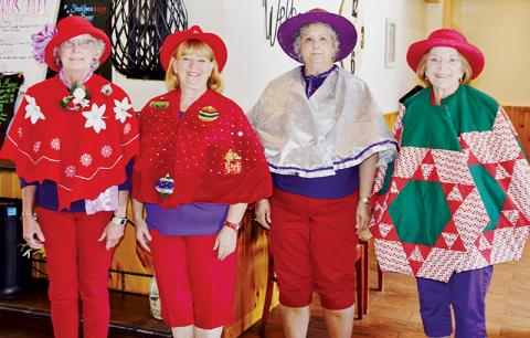 Susan Lyons, Deborah Cheney, Joyce Mitchell and Glenda Raulerson (from left) participated in the “Tree Skirts” contest, one of several fun-filled festivities the Red Hat Ladies enjoyed at Saturday’s “Christmas in July.” Photo by Art Miller/amiller@grahamstar.com
