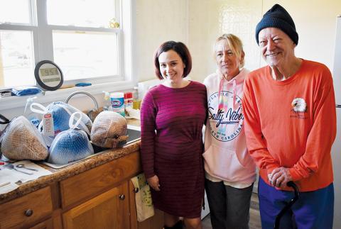 Brandi Oocumma, Tracy Bradley and Bob Culler (from left) with all the meat the family will serve for the second community Thanksgiving it has hosted on Snider Circle. Photo by Charlie Benton/news@grahamstar.com