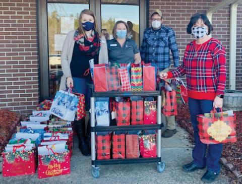 United Community Bank representatives Adara Crisp and Monica Farley (back left, center) teamed up with Graham Healthcare & Rehabilitation’s Tim Adams to spread Christmas joy to residents at the long-term care facility. Standing in front is bank manager Pam Shaffer.