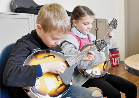 Joshua Kamps (left) and Calista Holder – both 9 – refine their mandolin craft as part of the Stecoah Valley Cultural Arts Center’s Junior Appalachian Musicians (JAM) program on Feb. 17. Photos by Charlie Benton/news@grahamstar.com