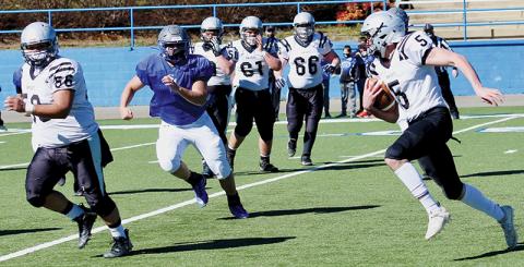 With Carlos Wesley (56) running interference, senior quarterback Nathan Collins takes off on a keeper during Saturday’s scrimmage at Smoky Mountain. Photos by Miranda Buchanan/Robbinsville High School Yearbook