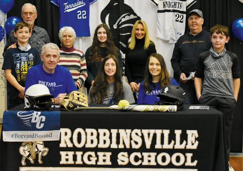 Robbinsville senior Gabby Hooper (center, seated) signed her letter of intent to play college softball with Brevard on Monday. Sitting with Hooper are parents Gabe and Crystal Hooper. Standing in back (from left) are brother Loxston Hooper, grandparents Clayton and Lana Hooper, sister Delaney Hooper, grandparents Patricia and Donald Cable, and brother Lleyton Hooper. Photo by Kevin Hensley/editor@grahamstar.com