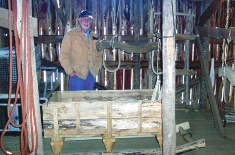 Buster Stewart stands with two of his creations: a yoke and a sled. Photo by Marshall McClung/The Graham Star