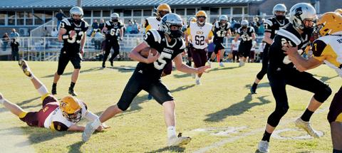 Black Knights quarterback Nathan Collins (5) leaves Cherokee’s Chase Calhoun (8) in the dust during Saturday’s home game against the Braves. Collins had two rushing touchdowns in Robbinsville’s 35-14 victory. Photo by Art Miller/amiller@grahamstar.com