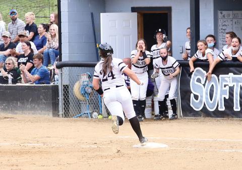 With her teammates celebrating in the dugout, Ivy Odom turns the third-base bag after hitting a 2-run homer during Tuesday’s 11-6 victory over Murphy. The win put Robbinsville in a first-place tie atop the Smoky Mountain Conference standings. Photo by Miranda Buchanan/Robbinsville High School Yearbook