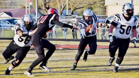 Carlos Wesley (56) and Candler Edwards (50) make sure that Lex Hooper has room to run during an April 2 game in Andrews. The trio were three of 15 Robbinsville players recently named All-Smoky Mountain Conference. Photo by Art Miller/amiller@grahamstar.com