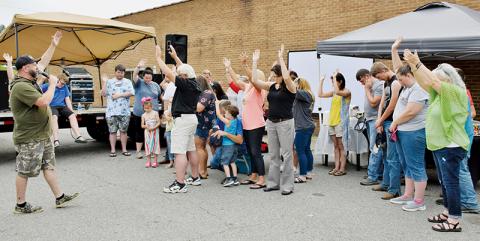 Kevin Seagle leads those gathered at Saturday’s Community Outreach Cookout in prayer. Photos by Art Miller/amiller@grahamstar.com
