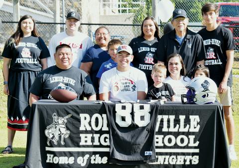 Rossi Wachacha (seated, center) signed his letter of intent to play college football at Lenoir-Rhyne University on June 30. Front row (from left) are father Jeremy Wachacha, Rossi, brother Jace Smith, mother Melissa Smith and sister Jaxtyn Bark. Standing in back (from left) are Rossi' girlfriend Tishara Sneed, friend Court Carpenter, aunt Jennifer Wachacha, cousin Cannon Gross, aunt Paige Gross, grandfather Wayne Wachacha and cousin Dasan Gross. Photo by Kevin Hensley/sports@grahamstar.com
