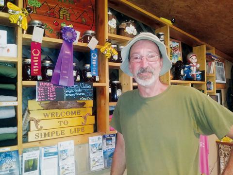 Simple Life Mountain Retreat proprietor Alan Walmsley beams while showing the two awards he won for his honey at the Swain County Agricultural Fair. Walmsley’s sourwood honey took Best in Show and first place, while his dark honey netted a second-place finish. Photos by Charlie Benton/news@grahamstar.com