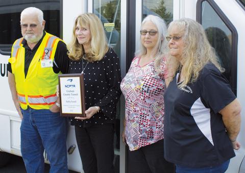 Graham County Transit lead driver Terry Crawford, director Juanita Colvard, assistant director Tracy Jenkins and dispatcher/scheduler Donna Hill (from left) pose with the safety award the system received from the N.C. Public Transit Association. Photo by Charlie Benton/news@grahamstar.com