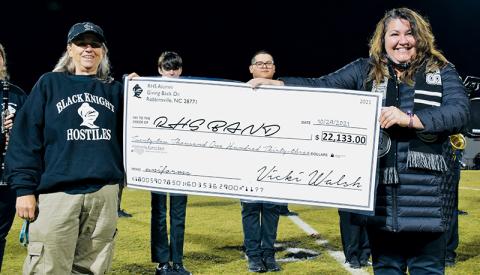 Vicki Walsh (left) presents a check to Robbinsville High School Band before Oct. 29’s home football game against Amber Watkins. At the time, the community-wide effort to raise money for new band uniforms had netted $22,133 – but now, the total has eclipsed $23,000. Photo by Art Miller/amiller@grahamstar.com