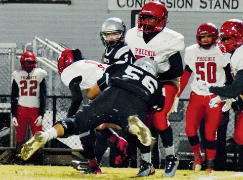 Senior lineman Carlos Wesley drops Winston-Salem quarterback Montell Austin (1) during the first half of Friday’s 66-14 first-round playoff victory over the Phoenix. Wesley had three sacks in the showcase for the Knights. Photos by Art Miller/amiller@grahamstar.com