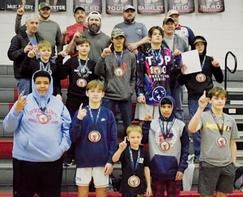 Members of Robbinsville’s youth program take a  moment with coaches and parents to relish their state championship victories on Feb. 5 in Advance. Shown are wrestlers (front row, from left) Bracey Wilson,  Loxston Hooper, Lawton Gibby, Adair Panama and Lleyton Hooper; Benton Gibby, Braydon Lane, Andrew Adams, Kyler Branham and Mason Phillips (second row, from left).