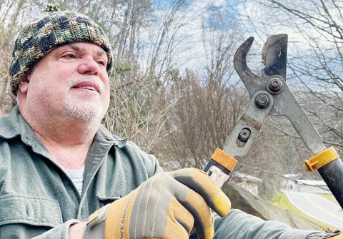 Torey Bennett shows the loppers damaged when he tried to trim limbs overhanging a power line behind his house off Meadow Branch Road. Photos by Randy Foster/news@grahamstar.com