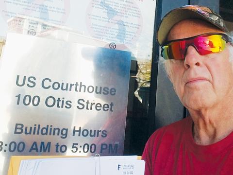 Gerry Laschober poses at the federal courthouse in Asheville on Monday, when he filed his response to a defendant’s motion to dismiss.
