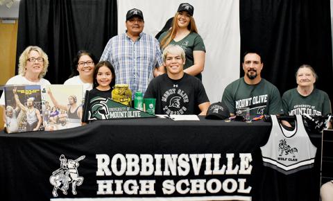 Ben Wachacha (seated, center) signed to wrestle for the University of Mount Olive on Friday. Seated with Wachacha are (from left) grandmother Debbie Bird, mother Monaka Wachacha, sister Amara Wachacha, father Randy Wachacha and grandmother Carolyn Wachacha. Standing in back are grandfather John Bird (left) and sister Aubrie Wachacha. Photo by Kevin Hensley/sports@grahamstar.com